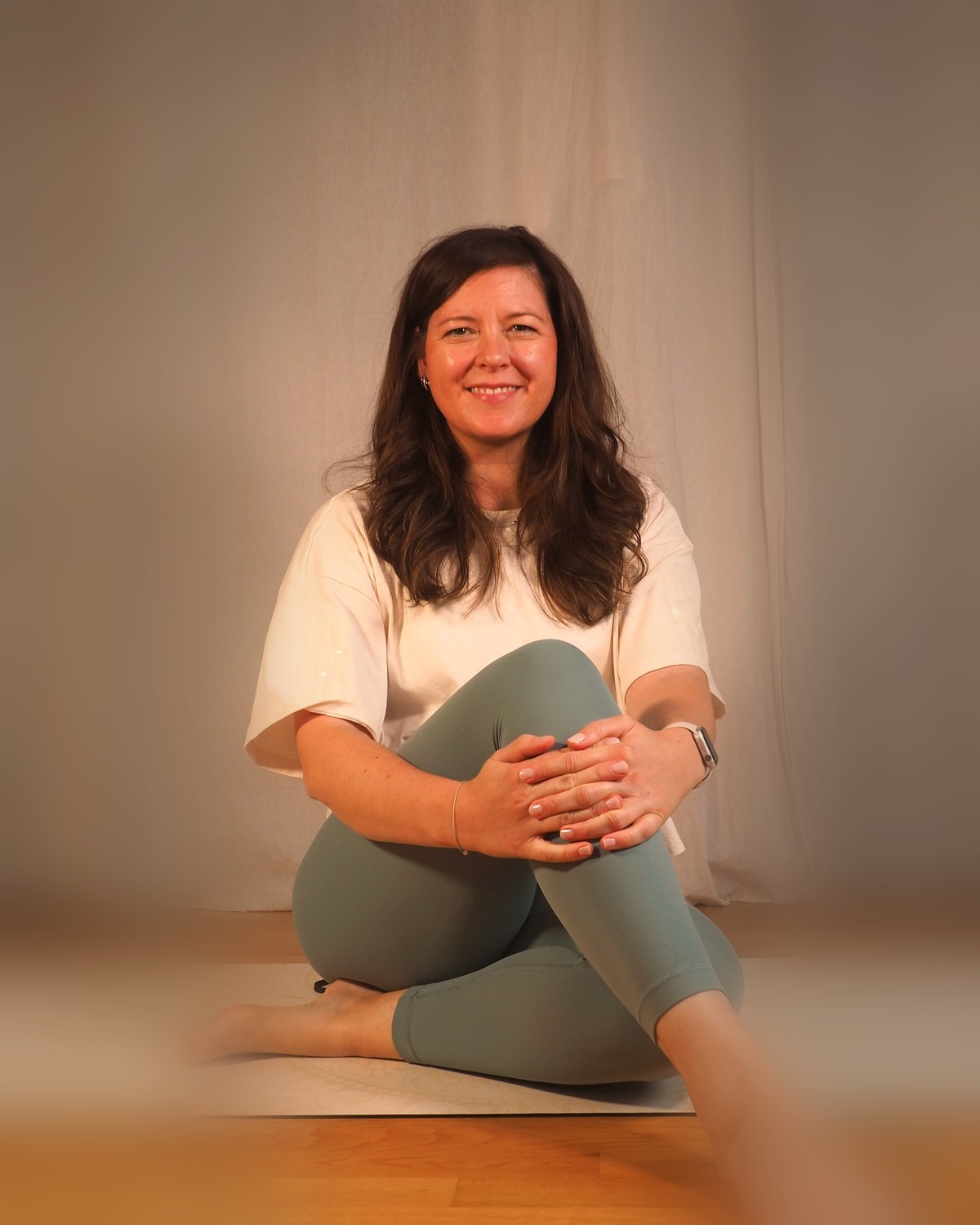 Steffi, Pilates-Trainerin bei Nusa Pilates, ruhig lächelnd auf der Matte
